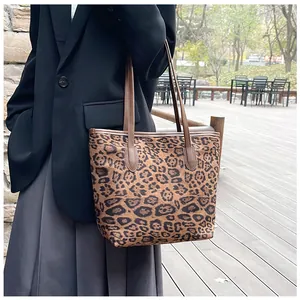 Borsa tote leopardata con cinturini in pelle marrone mostrata su modella per uno stile chic