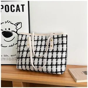 Detail of black and white striped tweed tote bag with cream leather straps and gold rivets