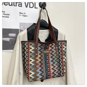 Details der Vintage-Canvas-Tasche mit Chevron-Muster, Ledergriffen und goldenen Nieten