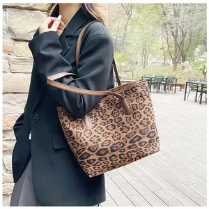 Dettaglio della borsa tote leopardata con manici in pelle marrone e trama di tela