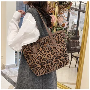 Dettaglio della borsa tote leopardata con cinturini in pelle marrone sulla spalla