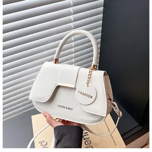 Détail du sac selle blanc avec ferrures dorées et texte embossé Fashion & Bags