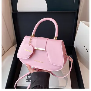 Détail du sac selle rose avec barre métallique dorée et étiquette Fashion en coffret