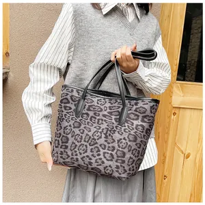 Dettaglio della borsa shopper leopardata con manici in pelle nera e interno capiente