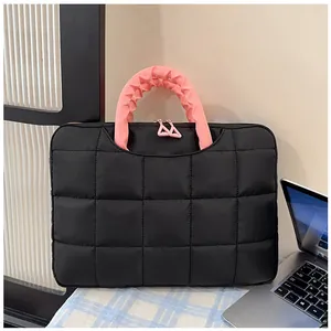 Dettaglio borsa porta PC trapuntata nera con manico rosa a volant e cerniera a triangolo