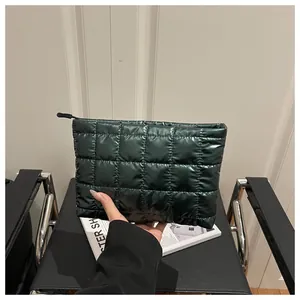 Close-up of a dark green quilted makeup bag featuring a puffy metallic finish texture