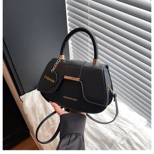 Gros plan détaillé d'un sac selle en cuir noir avec ferrures dorées et texte embossé