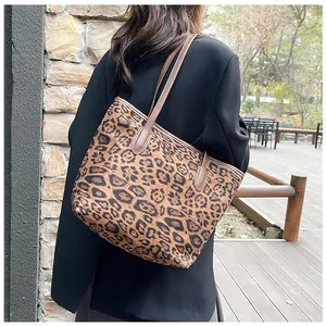 Dettaglio della borsa tote leopardata con spalline in pelle marrone indossata a spalla