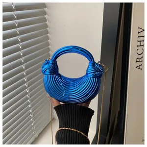 Dettaglio della borsa a mano plissettata blu elettrico con finitura metallica e oro