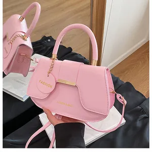 Détail du sac selle rose avec logo FASHION doré et texture en cuir lisse élégant