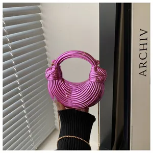 Dettaglio borsa hobo rosa metallizzato con texture a onde, manico a nodo e catena oro