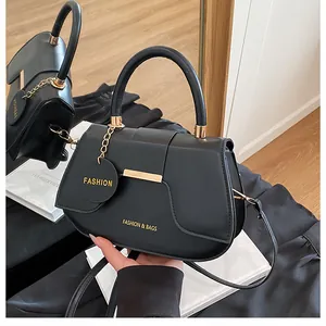 Détail du sac selle en cuir noir mat avec logo doré et finitions métalliques dorées