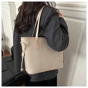 Beige oversized tote bag with leather straps styled on model for urban commute