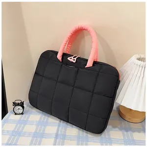 Dettaglio borsa per laptop trapuntata nera con manici rosa e cerniera a triangolo
