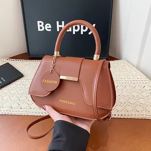 Sac à main selle en cuir marron avec détails dorés élégants et bandoulière pour femme