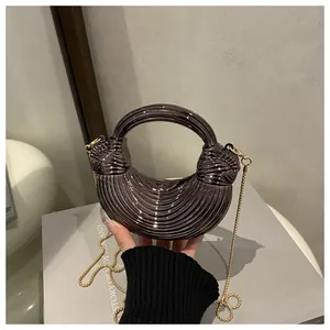 Dettaglio della borsa grigio metallizzato con motivi lineari e design del manico a nodo