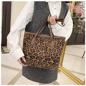 Dettaglio della borsa tote leopardata con manici in pelle marrone e interno capiente