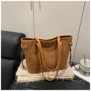 Detail of brown faux suede tote bag featuring drawstring accents on soft knit fabric