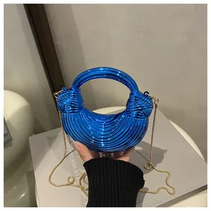 Dettaglio borsa a mezzaluna blu Klein con catena dorata e trama metallica a pieghe 3D