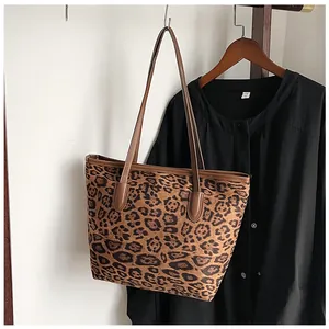 Dettaglio della borsa shopper leopardata con manici in pelle marrone e cuciture