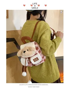 Détail d'un sac à dos en peluche à carreaux roses avec décor de chiot et étiquette brodée