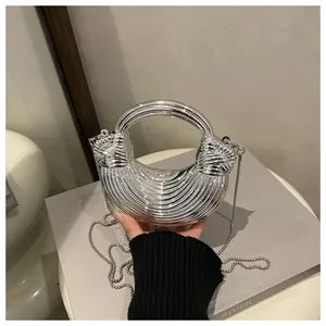 Dettaglio della borsa a mezzaluna argento con texture a costine orizzontali e catenina