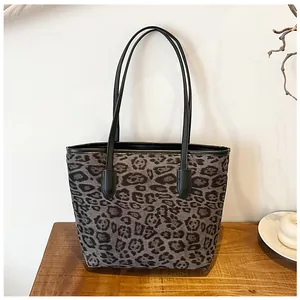 Dettaglio della borsa tote leopardata su un tavolo di legno con decorazioni eleganti