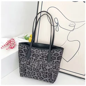 Dettaglio della borsa tote leopardata grigia con bordo in pelle nera in stile moderno