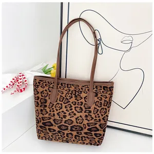 Dettaglio della borsa leopardata con trama in tela e manici in ecopelle marrone