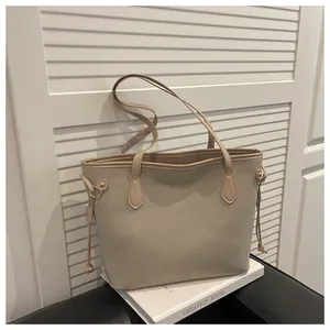 Detailed close-up of apricot tote bag featuring long slim straps and side drawstring accents