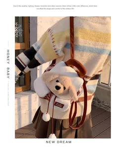 Détail d'un mini sac à dos chien en peluche avec motifs à carreaux et pompons