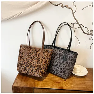 Dettaglio di borse tote leopardate marroni e grigie con grande capacità su tavolo in legno