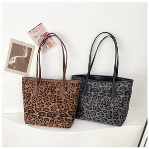 Dettaglio delle borse tote leopardate in marrone e grigio con cuciture rinforzate sui manici