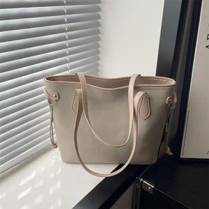 Retro large beige tote bag in suede texture with side drawstrings on a sunny window sill