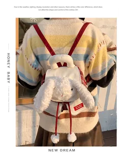 Détail d'un sac à dos lapin en peluche blanche avec de longues oreilles et bretelles