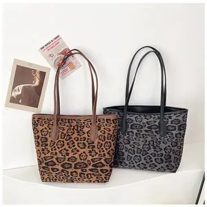 Vista dettagliata di grandi borse tote leopardate in marrone e grigio con manici lunghi