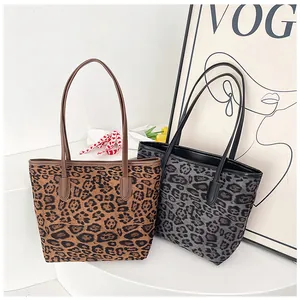 Dettaglio di grandi borse tote leopardate in marrone e grigio con sottili tracolle
