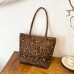 Borsa tote con stampa leopardata e manici marroni su una scrivania in legno elegante