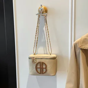 Mini sac bandoulière en daim beige avec chaîne dorée et logo métallique circulaire