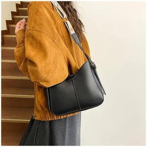 Detail of minimalist black hobo bag with vintage geometric woven wide shoulder strap