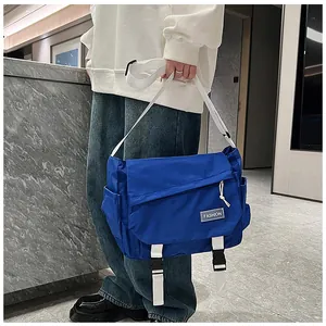 Close-up of blue messenger bag with white buckle and fashion patch on fabric strap