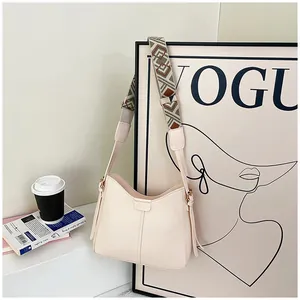 Detail of cream leather shoulder bag featuring a geometric woven wide strap design