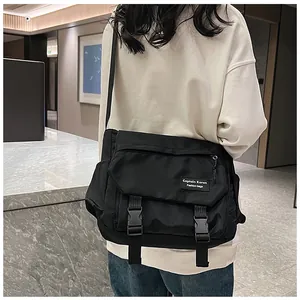 Detail view of large black waterproof nylon messenger bag with buckle closure and label