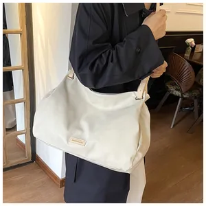 Detail of off-white oversized tote bag showing supple faux leather texture and metallic rings