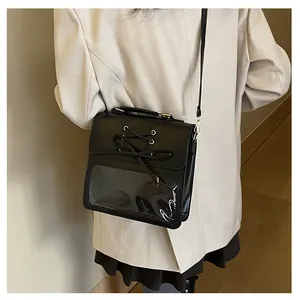 Detailed view of black commuter ita bag with clear window and ribbon on a model