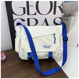Detail of white nylon messenger bag with blue strap and black dual buckle closure
