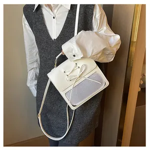Close-up of white synthetic leather bag with bow accent and mesh window for display