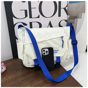Detail of white nylon messenger bag with blue straps and secure buckle closures