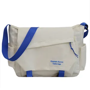 Minimalist canvas messenger bag in off-white with royal blue straps and side pockets