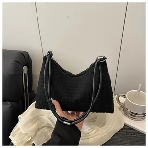 Détail du sac hobo en velours côtelé noir avec texture géométrique et anneaux argent